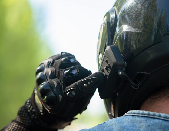 Motociclista encendiendo auriculares mientras se prepara para conducir