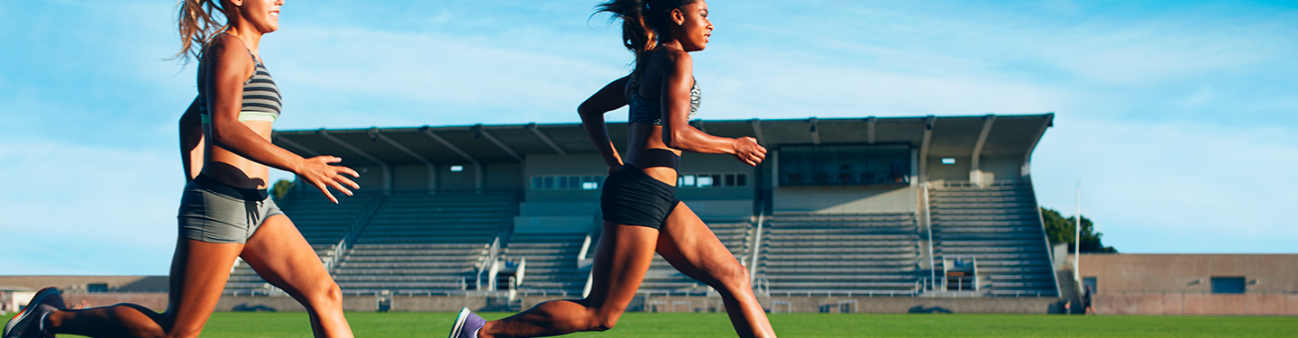 Dos atletas corriendo por una pista de atletismo