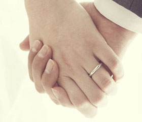 Dos manos agarradas mientras se casan